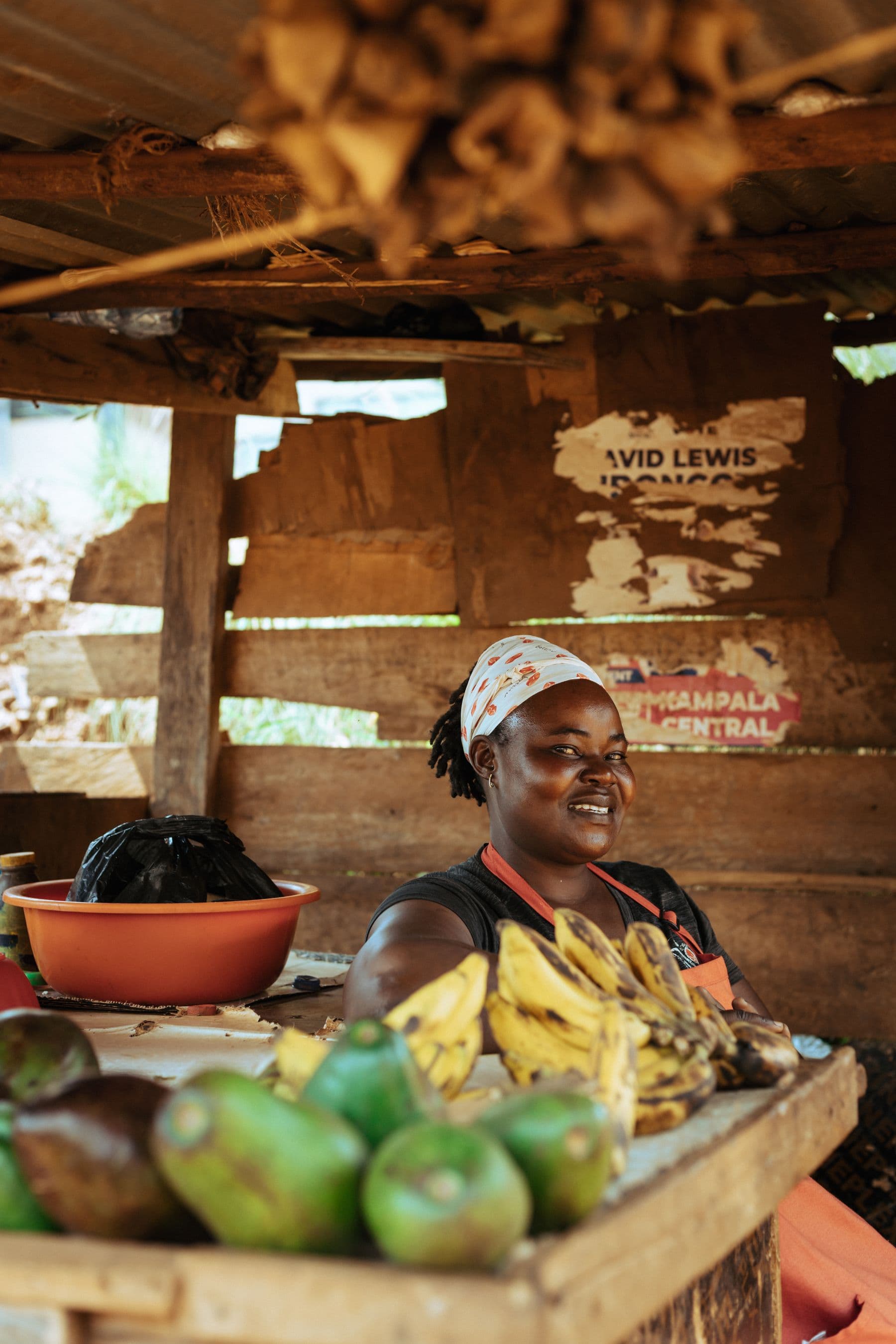 A market vendor smiling beside her produce stall